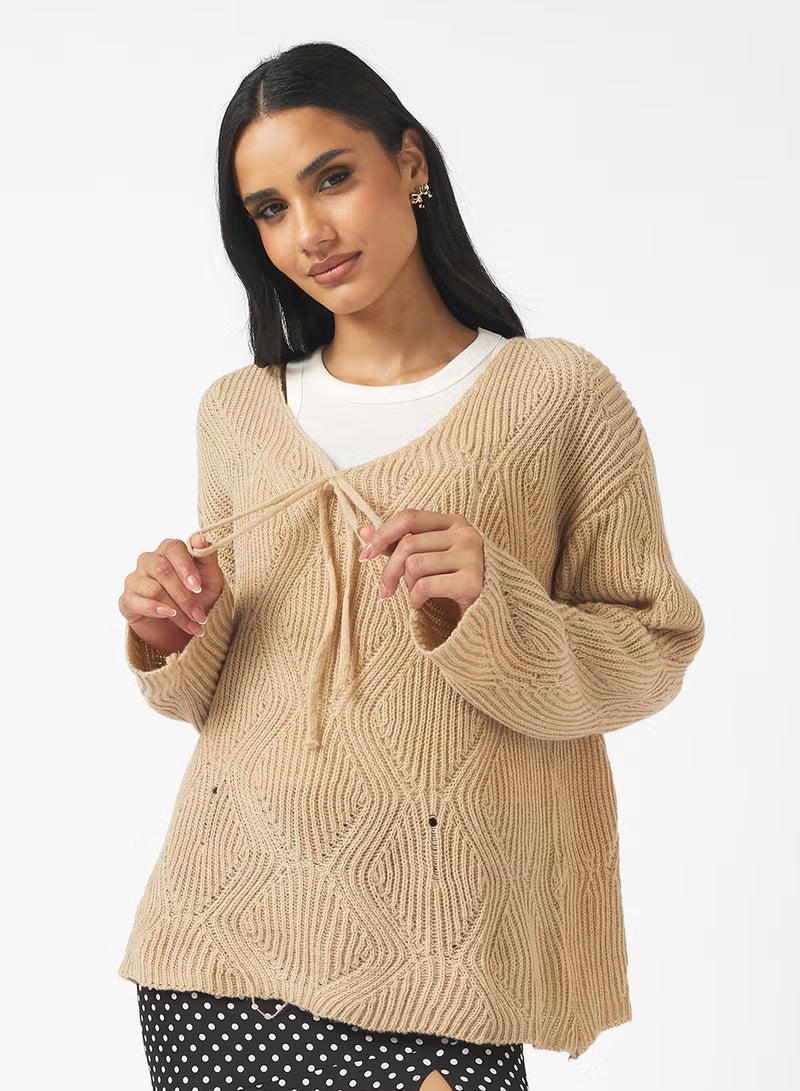 Pull-over en maille oversize pour femmes avec décolleté en V, cordon de serrage et structure en losanges